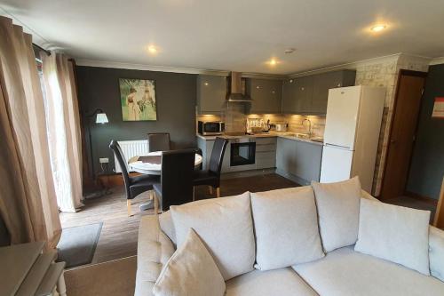 un soggiorno con un divano bianco e una cucina di Harvest 8 Lodge, Yellowtop Country Park a York