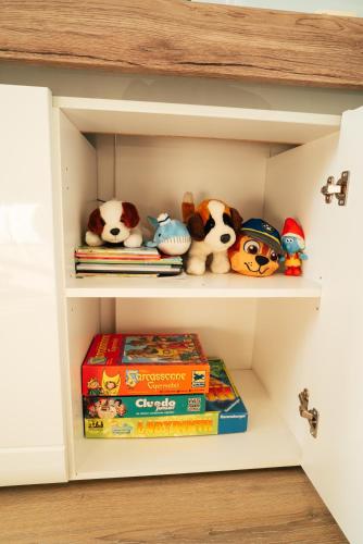 a book shelf with stuffed animals and books at Orchidea Wellness Apartman in Zalakaros