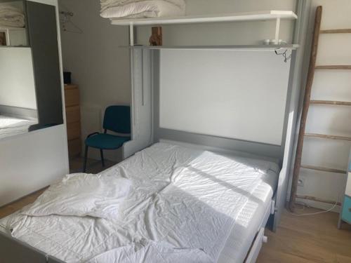 une chambre avec un lit blanc et une chaise bleue dans l'établissement Chambre au calme avec salle d'eau entre le centre de Vannes et la forêt de Saint Avé, à Vannes
