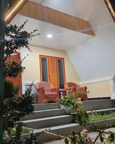 a porch with two chairs and some stairs at UNIQDO Inn Tomok in Tomok