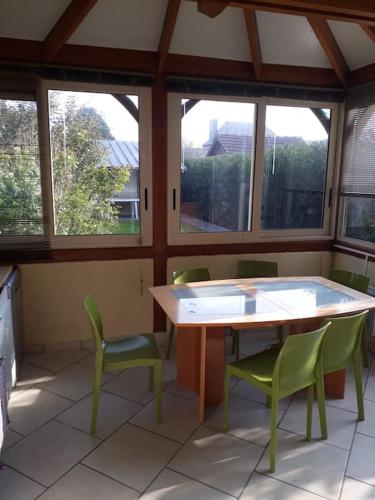 une pièce avec une table, des chaises et des fenêtres dans l'établissement Gite en bord de mer en Normandie, à Saint-Pierre-en-Port