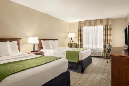 um quarto de hotel com duas camas e uma televisão em Country Inn & Suites by Radisson, Lima, OH em Lima