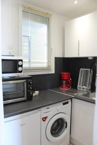 une cuisine avec un lave-linge et un micro-ondes dans l'établissement Charmant studio climatisé proche plage et animations - 3HYPO10, à Saint Cyprien Plage