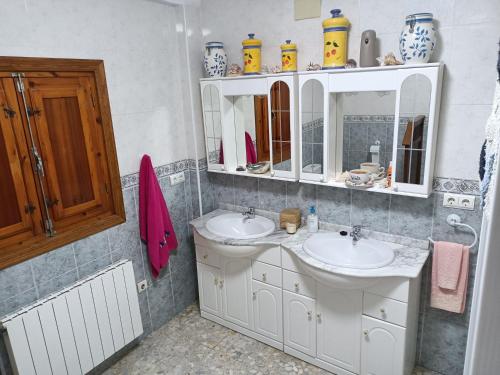 a bathroom with two sinks and a mirror at Casa De Aventuras in Bácor
