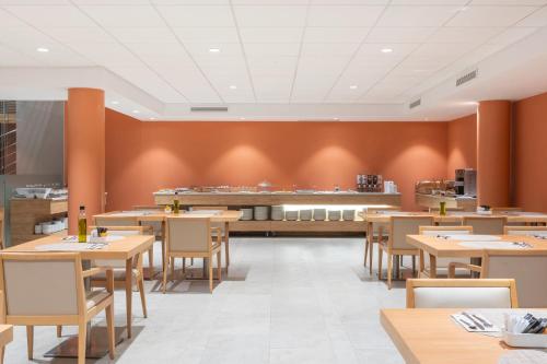 a restaurant with wooden tables and chairs and a counter at Acta Sant Just in Sant Just Desvern