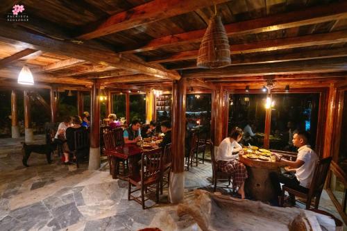 a group of people sitting at tables in a restaurant at Pachidua Ecolodge - Homestay Du Già in Làng Cac