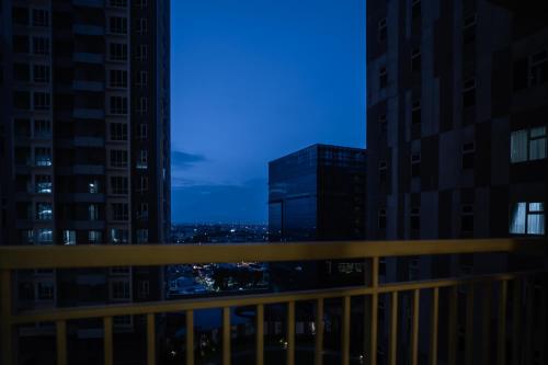 a view of the city at night from a balcony at AW Home at Podomoro City Medan in Medan
