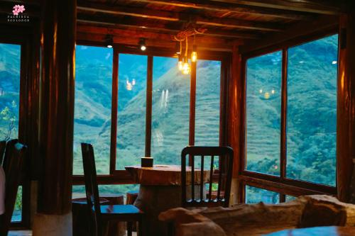 a room with a table and chairs and a large window at Pachidua Ecolodge - Homestay Du Già in Làng Cac