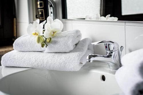 a pile of towels sitting on a bathroom sink at Hotel Avenue Altenfurt in Nürnberg