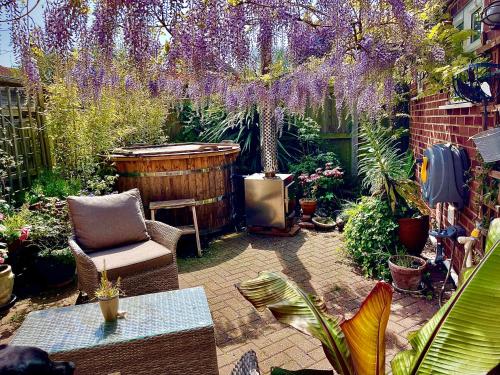 a garden with purple wisterias hanging over a patio at Avenue_1Barnes in Westgate on Sea