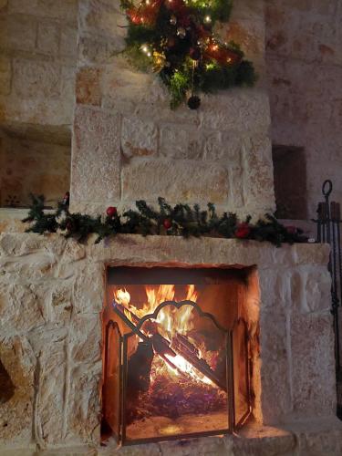 a fireplace with a christmas tree on top of it at Milura Home - con vasca idromassaggi in Locorotondo