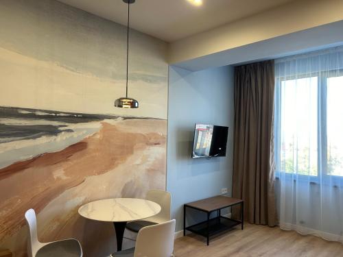 a room with a table and a painting on the wall at 1-Bedroom Apartment Modern, Near Downtown, with Issyk-Kul vibes in Karakol