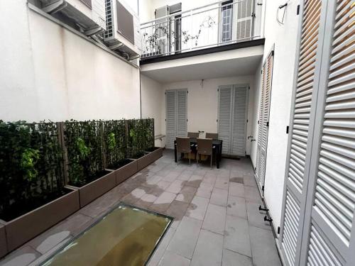 a small courtyard with a table and a dining room at Bosazza 20 in Parma