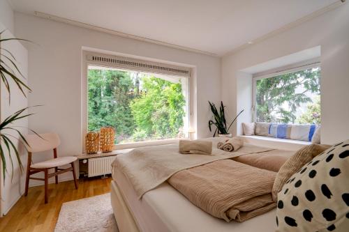 a bedroom with a large bed and a large window at Beheizter Whirlpool und Panoramafenster vom Bett ins Grüne! in Kassel