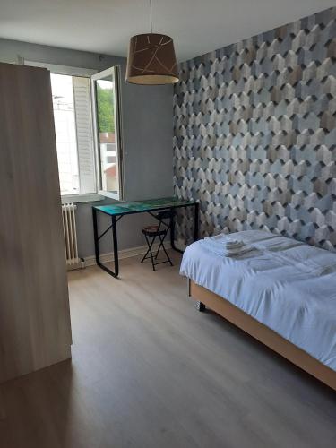 une chambre avec un lit et une table dedans dans l'établissement Appartement agréable, à Grenoble