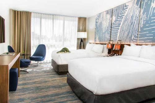 a hotel room with two beds and a desk at B Ocean Resort Fort Lauderdale Beach in Fort Lauderdale