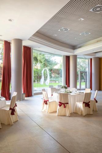 a banquet hall with white tables and chairs and windows at Acta Sant Just in Sant Just Desvern
