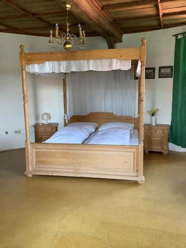 a bedroom with a canopy bed with white sheets at Ferienwohnung im Schloss Obersontheim in Obersontheim