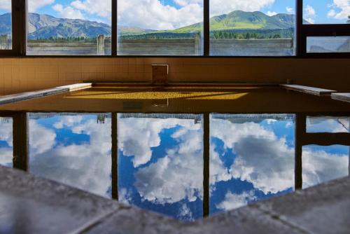 a room with a reflection of the sky in a pool of water at Kamenoi Hotel Aso Park Resort in Aso