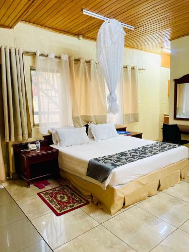 a bedroom with a large bed in a room at Kigali diplomat Hotel in Kigali