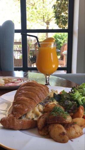 een bord eten met een broodje en een glas sinaasappelsap bij Kigali diplomat Hotel in Kigali