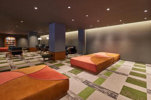a room with two beds and a table and chairs at Kamenoi Hotel Aso Park Resort in Aso