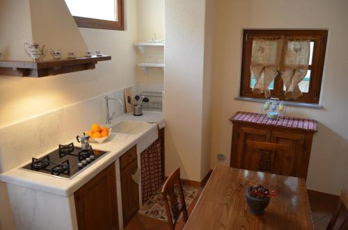 a kitchen with a stove and a sink and a table at Agriturismo del Pigato - Bio Vio in Albenga