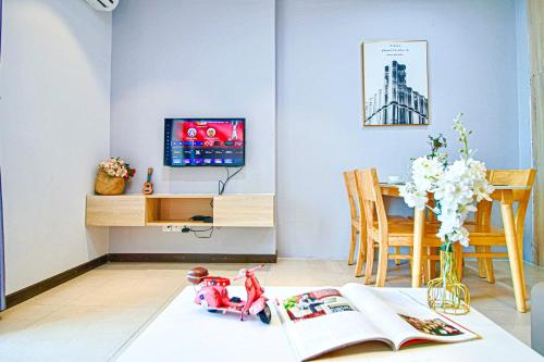 a room with a table with a book and a dining room at Classy Home - CSJ Tower Vũng Tàu, Luxury, Sky-Sea View and Walk-To-Beach in Xã Thang Tam