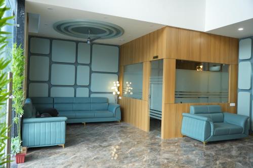 a waiting room with blue couches and a wall at Hotel Amrut Inn Hospitalities in Somnath