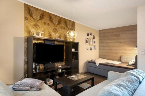 a living room with a couch and a flat screen tv at Kompass Oase in Burg