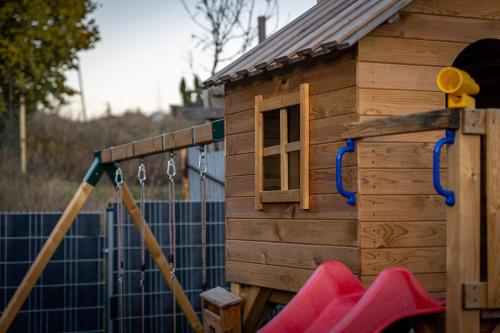 a wooden play house with a swing at Chaty Kukana a Kuku in Vysoké Tatry