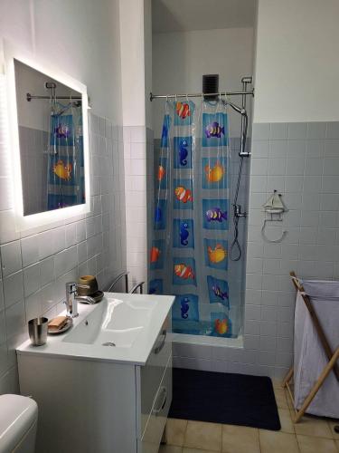 La salle de bains est pourvue d'un lavabo et d'une douche avec rideau de douche. dans l'établissement Direct sur plage pour ce charmant T2 avec parking privatif - 4OND28, à Saint Cyprien Plage