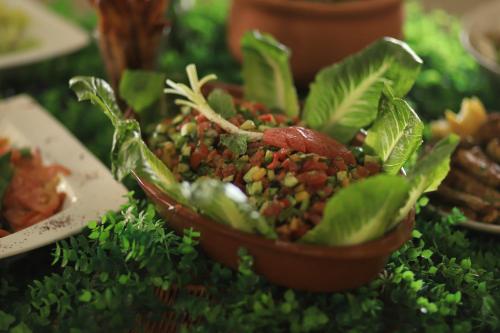 a bowl of food on a table with lettuce at Alqalah Restotel فندق ومطعم القلعة in Kerak