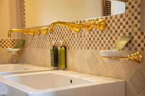 a bathroom sink with a gold faucet and a mirror at Castello Di Tornano Wine Relais in Gaiole in Chianti