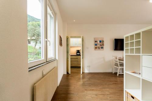 a living room with a large window and a table at Magic Terrace With Lake View in Stazzona