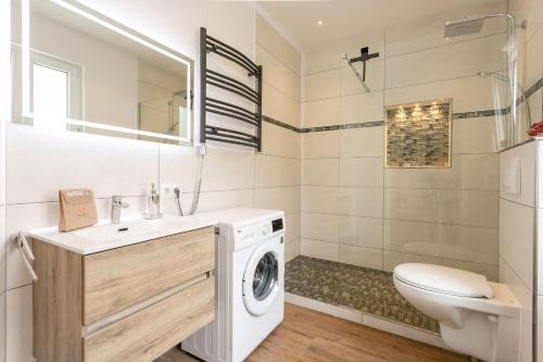 a bathroom with a washing machine and a toilet at Magic Terrace With Lake View in Stazzona