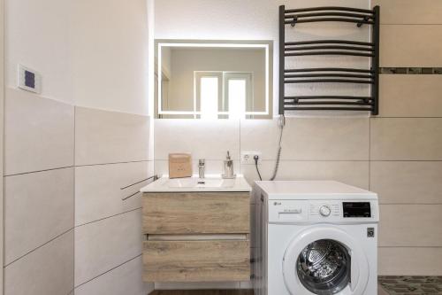 a bathroom with a washing machine and a sink at Magic Terrace With Lake View in Stazzona
