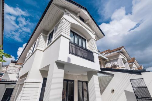 a white facade of a house with a balcony at 5BR Modern Luxury Pool Villa Patong TPSV140 in Patong Beach
