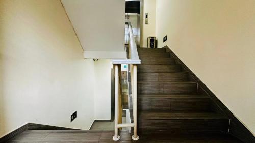 a staircase in a building with wooden floors and a railing at Shanghai Zhongan Hotel Xizang North Road Subway Station Branch in Shanghai