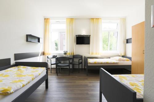 ハンブルクにあるBerne Apartmentsのベッド2台とダイニングルームが備わる客室です。