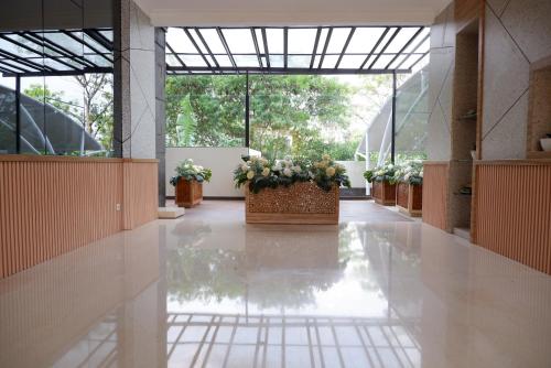 a hallway with potted plants in a building at Point C Hotel in Bandung