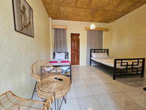 a room with two beds and a table and chairs at Acacia Sunset Village Inn in Dauis