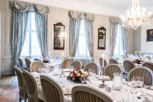 a dining room with a long table and chairs at Skjoldenæsholm Slot in Jystrup