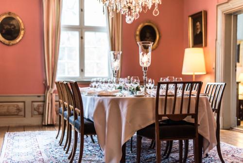 un comedor con una mesa con gafas. en Skjoldenæsholm Slot en Jystrup