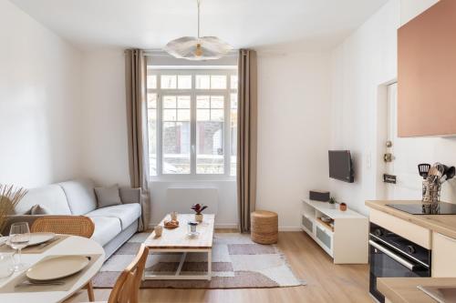 un salon avec un canapé blanc et une table dans l'établissement Terra Rosa - Apt à 5min de la plage, à Dinard