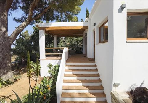 a staircase leading to a white house with a tree at Casa Agave in Denia