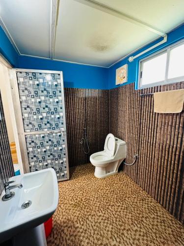a bathroom with a toilet and a sink at TULDA BAMBUSA RESORT in Kāziranga