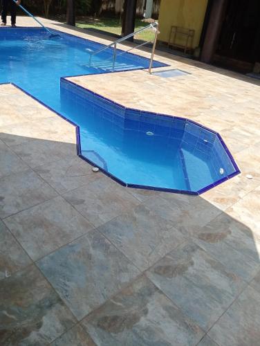 a swimming pool with a blue tile around it at Olivia Bungalow in Wattala