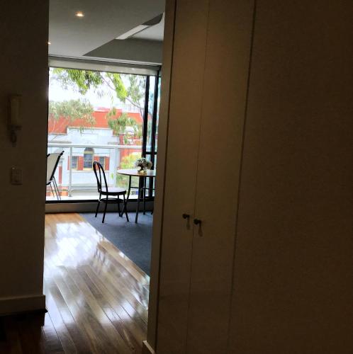 an open door to a living room with a table and chairs at The Waterfront Apartments Geelong in Geelong