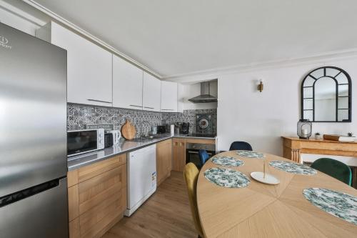 une cuisine avec une table en bois avec des chaises et une tableasteryasteryasteryasteryasteryastery dans l'établissement Bluestay 5- Superbe appartement à Paris, à Paris